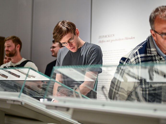 Besucher sehen sich Ausstellung an Besucher sehen sich Ausstellung an